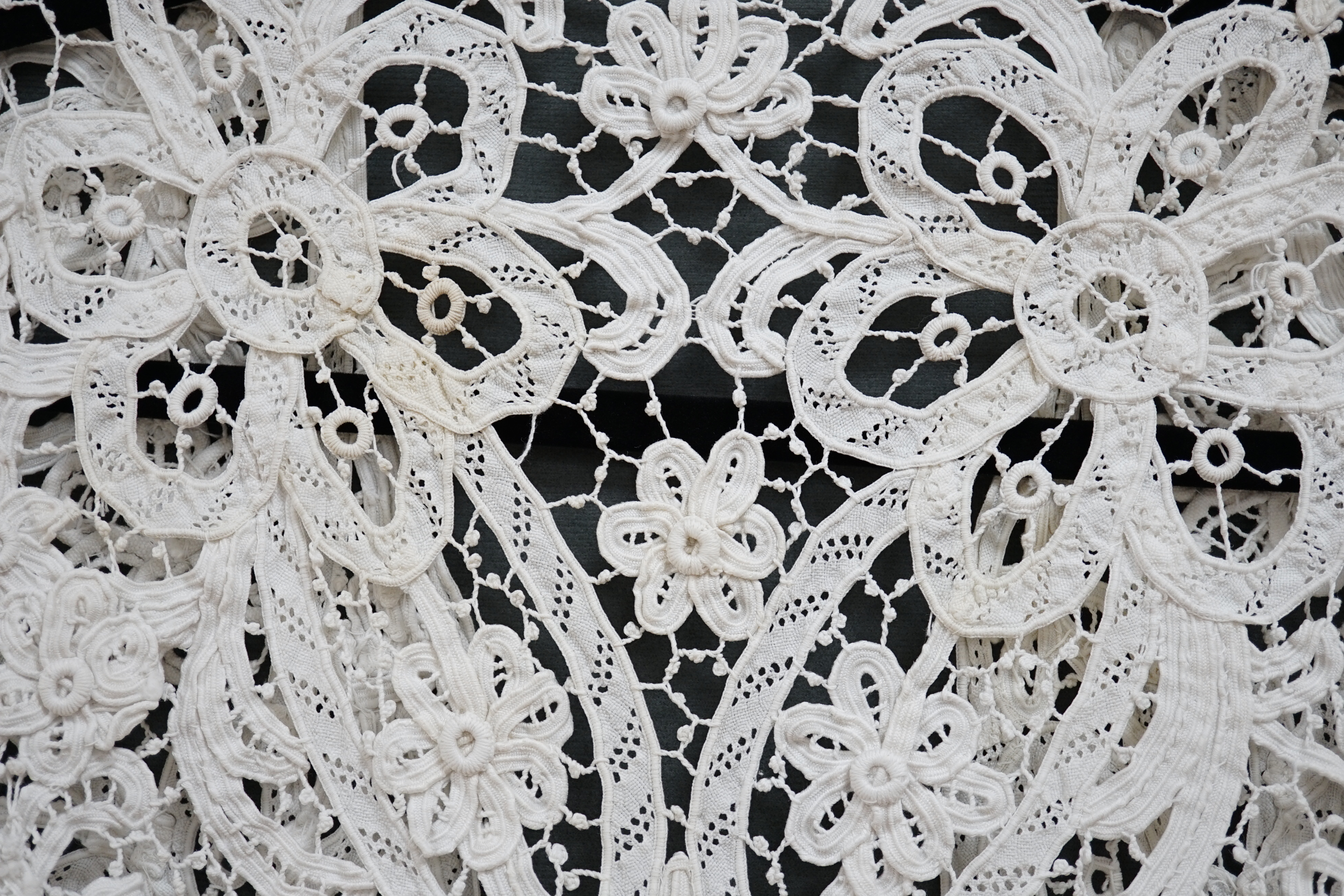 An Edwardian ladies white lace bolero, a tape lace Edwardian cap sleeve bolero with hand sewn bracts, attaching the tape lace together, possibly part of a wedding dress or summer dress, back under arm width 36cm. Conditi